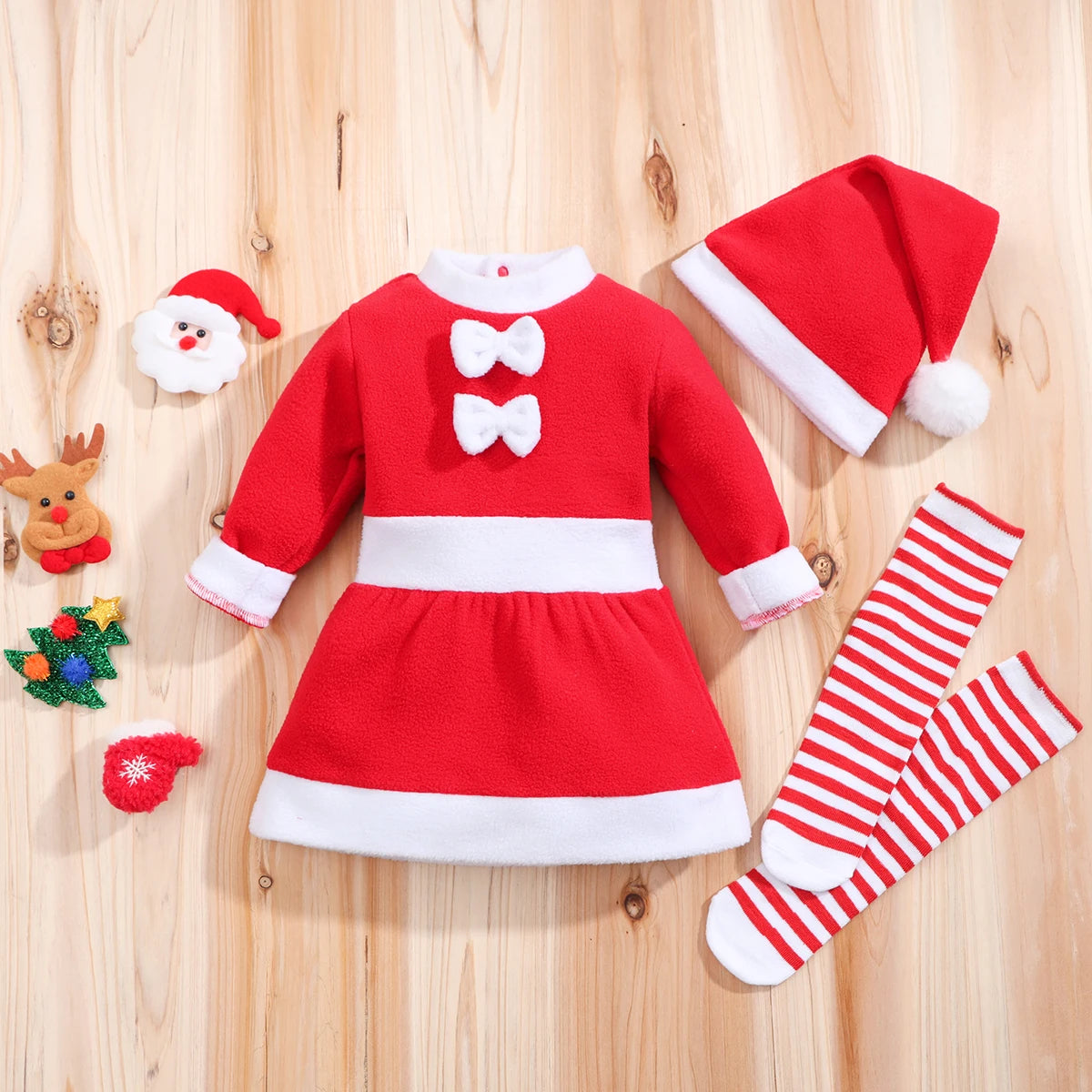 baby girl christmas dress set with hat and socks laid flat on wood background